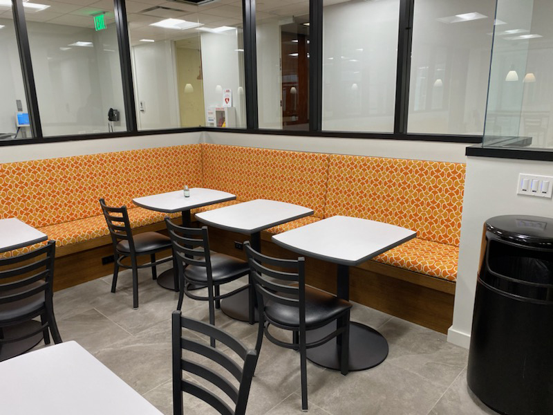 IMG_0514_800px Modern cafeteria interior with seating and decorative orange backsplash.